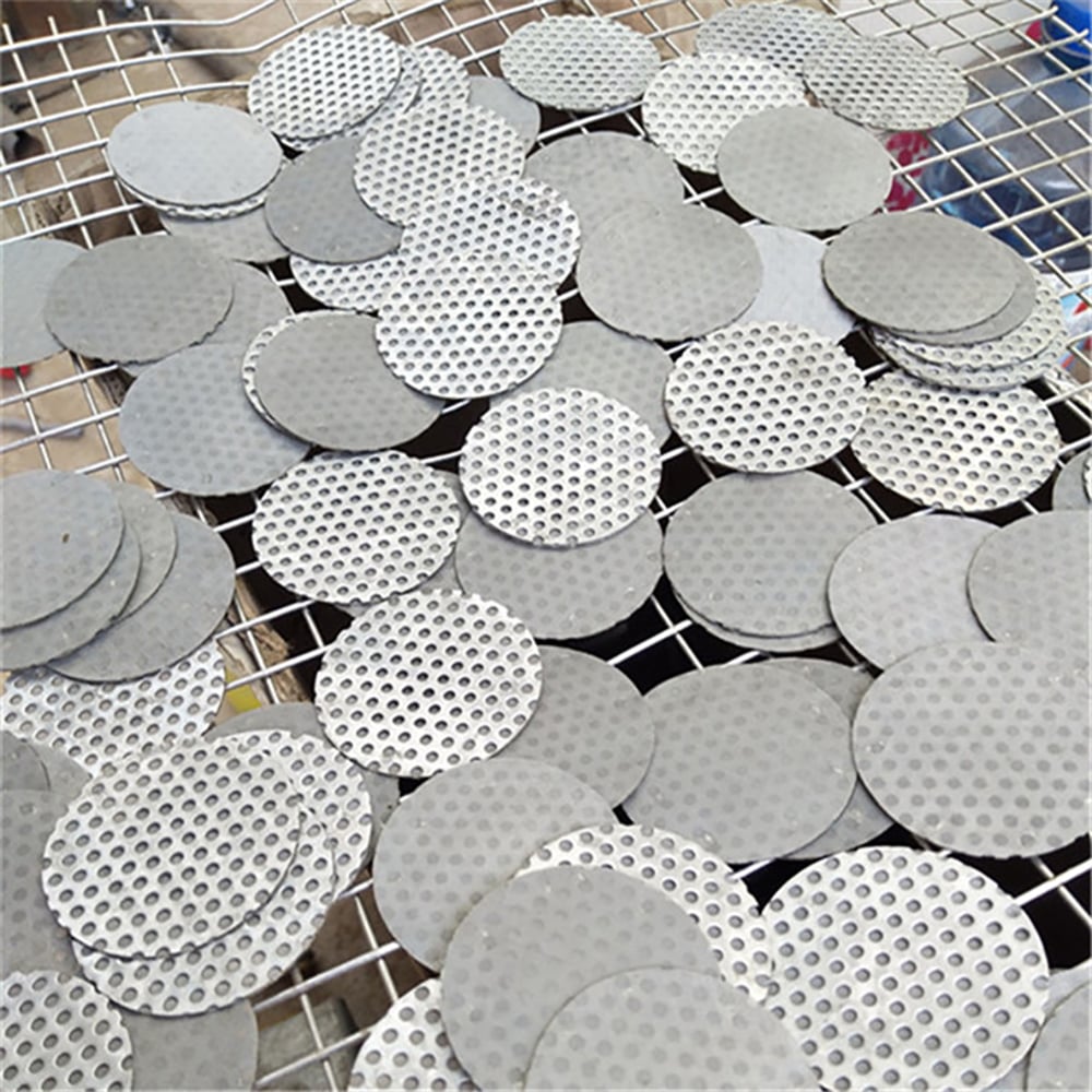 Custom round perforated metal filter discs in production