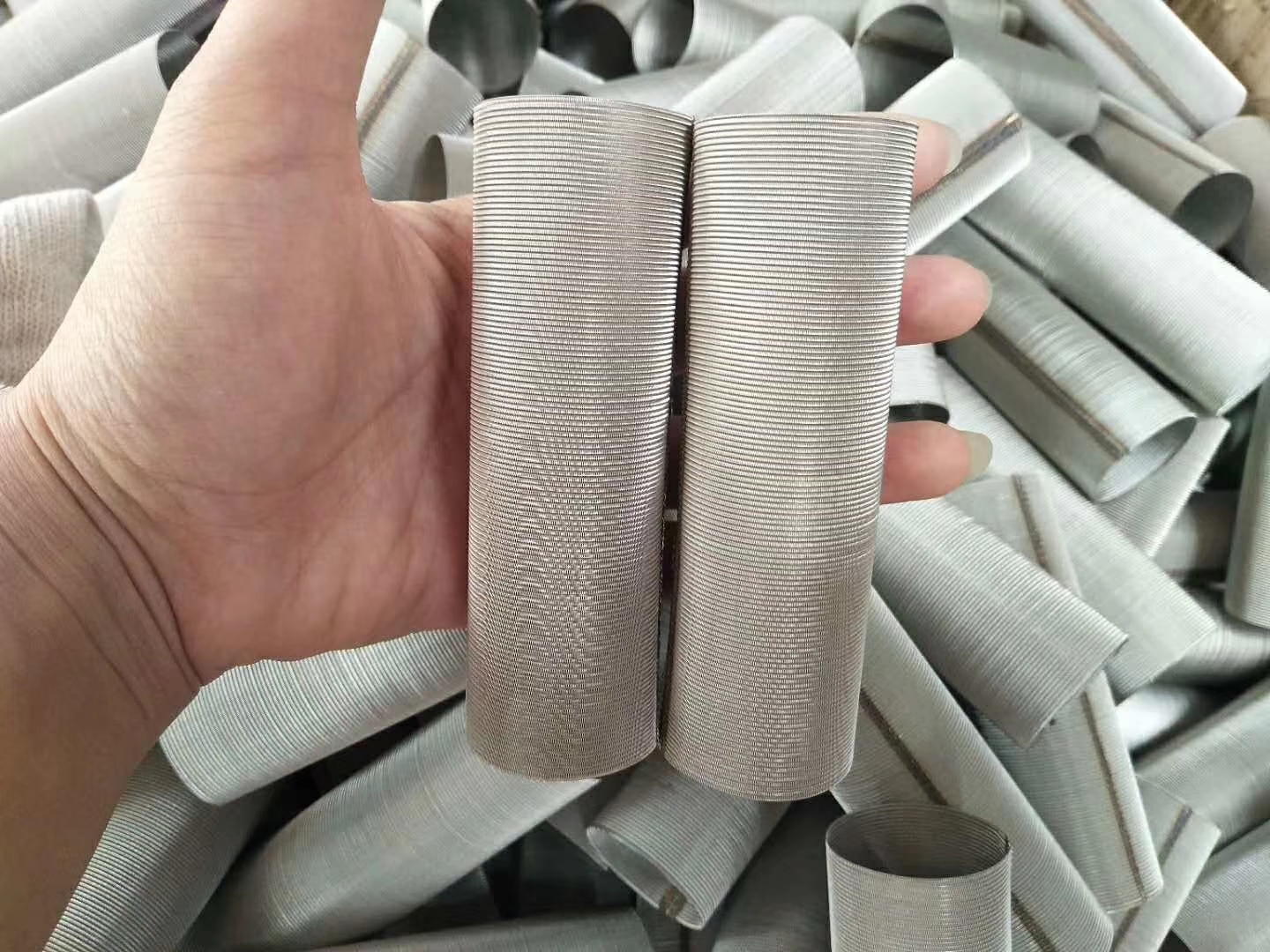 Stainless steel Dutch weave filter cylinder samples held for inspection
