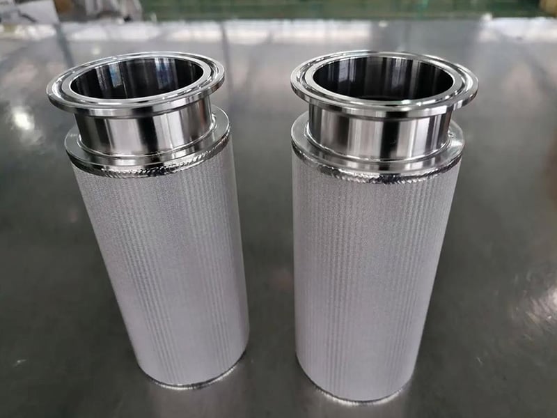 Two cylindrical sintered wire mesh filter cartridges with sanitary clamp fittings
